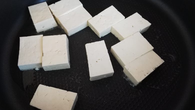 寿喜锅(日式牛肉火锅),锅里放入少许食用油,把切好的豆腐块放进去煎一下