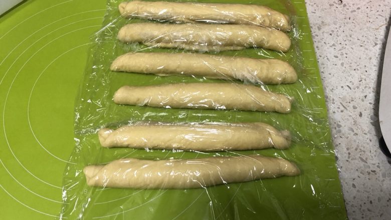 圣诞花环面包,从长边卷起面团,每一份都如此卷好,盖上保鲜膜松弛10分钟