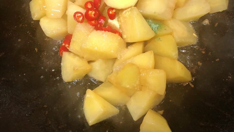 土豆烧肉,放入盐、<a style='color:red;display:inline-block;' href='/shicai/ 756'>鸡精</a>、蔬之鲜、辣椒、姜片,翻炒几下。