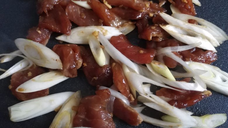 烧饼夹烤肉,电饼铛里放少许油,然后倒入腌制好的肉片和葱片