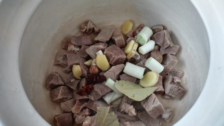 冬季养生暖身汤 羊肉萝卜汤,把羊肉和葱姜、调味料放入砂锅中