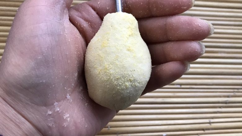 以假乱真的梨子馒头,面团揉成梨子的形状,可以用玉米面当薄面,揉好的梨子用筷子的小头在顶部扎个小洞,按梨把用