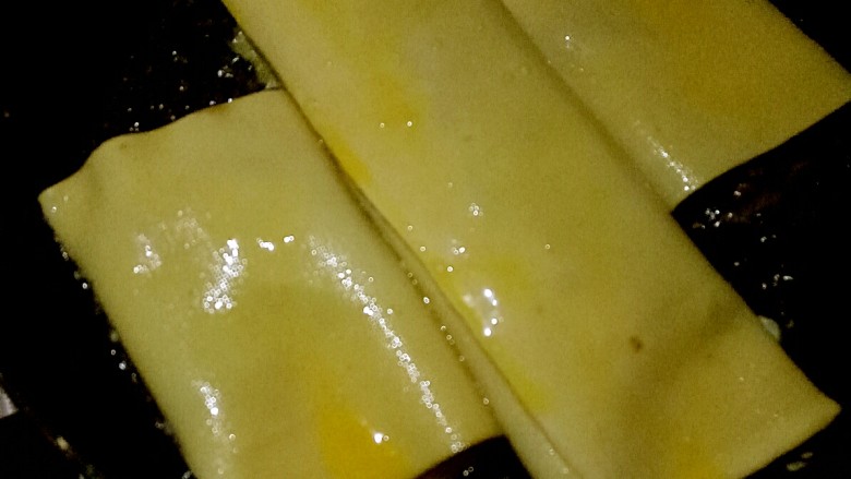 色香味俱全的豆腐皮卷煎,做法儿超级简单,营养又美味!,放入豆腐皮卷,为了省时间,可以把另一个豆腐皮卷横刀切断,一起放入平底锅中小火慢煎