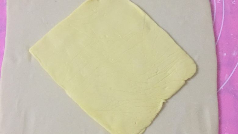 丹麦吐司(开酥吐司),取出面团,擀成大方片,然后斜对角放上刚才擀好的黄油片