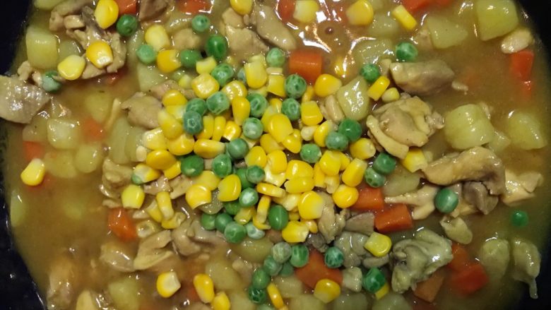 一天家咖喱鸡肉饭,炖煮大概10分钟后,开盖收汁,要不停搅拌,汤汁收的比较浓稠的时候加入豌豆玉米粒,翻拌均匀即可出锅。