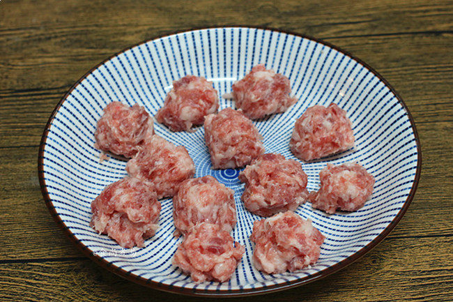 冬瓜鲜菇肉丸汤,抓起肉糜,肉丸从虎口处挤出,搓好的丸子放在一旁待用