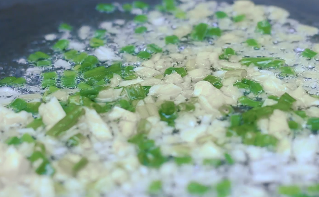 腊味焖饭,锅里热油,把蔬菜、葱姜蒜都倒进去翻炒。