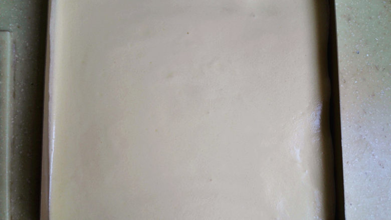 盒子蛋糕,倒入不粘烤盘里,表面刮平,再震出大气泡,如果烤盘不是不粘的,则要铺油纸或是油布防粘,