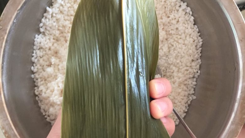 肉粽子,重点来了,把后面的叶子盖过来顺势用手压住右边的叶子