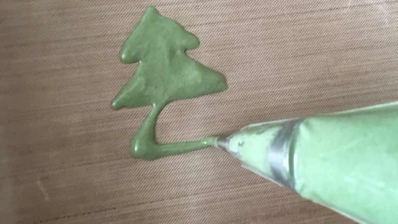 圣诞树蛋糕卷,拌匀的绿色蛋糕糊,装入裱花袋,挤出三角形叠加。