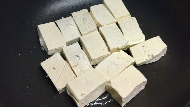 福建+酿豆腐,锅里放油,烧热,把酿豆腐肉馅朝下下入锅里煎,煎四五分钟表面金黄后,翻面。
