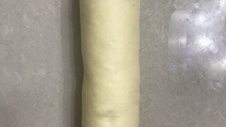 庞多米吐司,取一个面团收口朝下,用手掌拍打排气。
