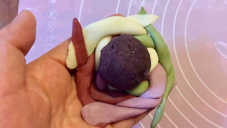 多彩绣球豆沙包,把编好的绣球皮翻面,把豆沙放中间。
