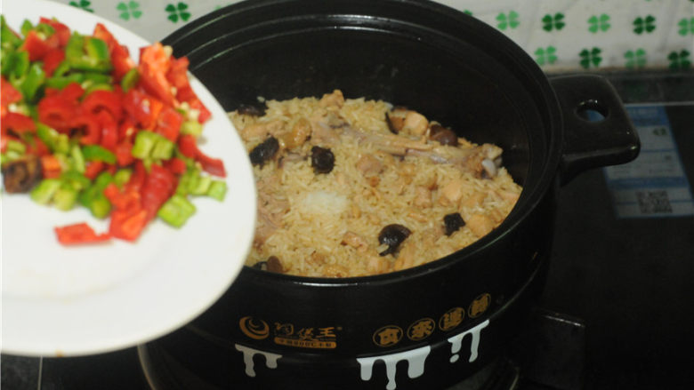 鸡腿饭,米饭煮好后开锅,将青红椒倒进去,翻拌均匀即可