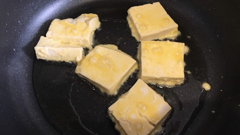 山东·锅塌豆腐,豆腐先在玉米淀粉里两面裹上一层淀粉,然后再鸡蛋液里滚一圈,锅内下食用油,热稍微热后下豆腐煎