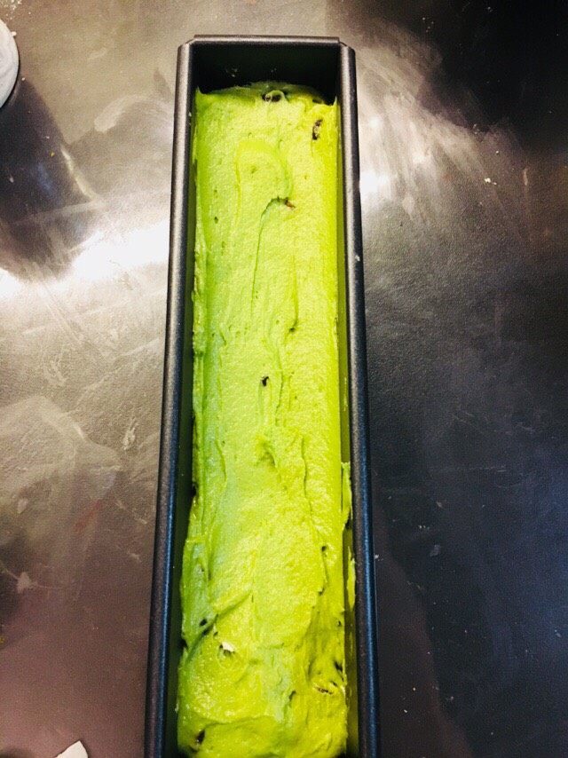 抹茶蜜豆磅蛋糕(分蛋法),挤好之后,震荡模具,让黄油糊之间没有空隙。将黄油糊抹成两头高中间低的样子。