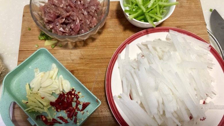 温补驱寒+白萝卜炒牛肉,白萝卜削皮清洗切丝,不用太细。青椒去蒂去籽清洗切丝,姜去皮清洗切丝,蒜头剥皮清洗切片,干辣椒去蒂清洗剪成细段
