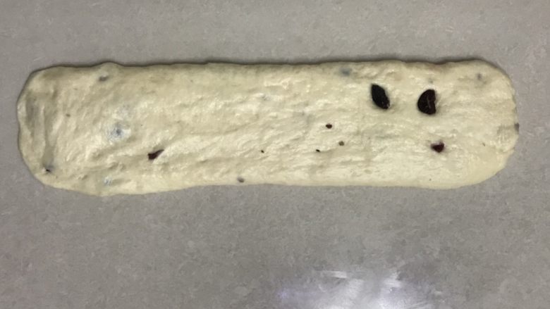 波兰种曼越梅吐司,取一个面团,收口朝下,用手掌拍打面团排气,用擀面杖擀开
