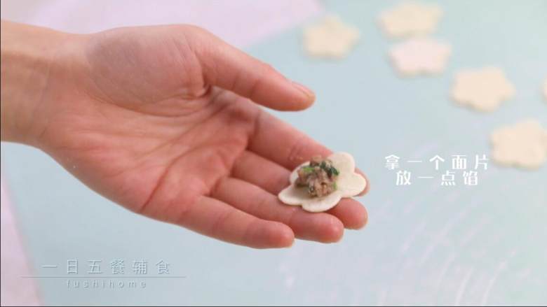 羊肉小水饺,拿一个面片,放一点馅,多一点馅最终鼓鼓的比较好看。另一个面片盖上,捏紧,捏起来的样子想要花纹明显,请沿着花型捏。