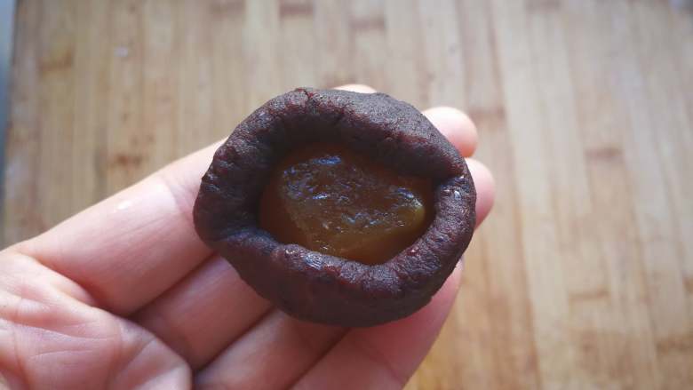 蛋黄酥 (超详细步骤),取一个豆沙馅按扁包入一个蛋黄,滚圆。