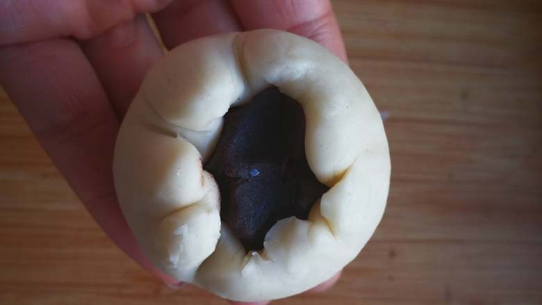 蛋黄酥 (超详细步骤),用擀面杖擀成面皮,包入一个包好蛋黄的豆沙球。包时先把面皮收到上面。