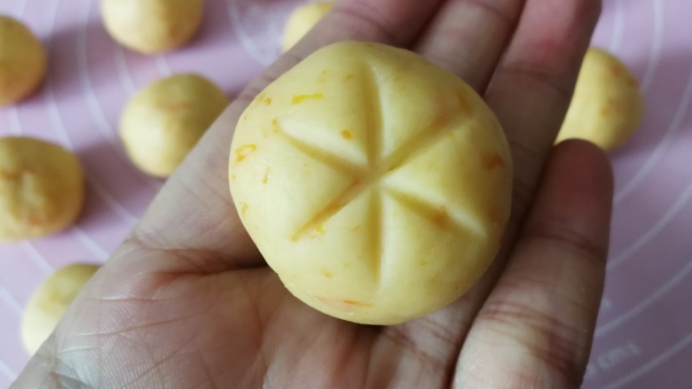 南瓜饼干,取一个面团,用牙签在顶部交叉压出三道印子