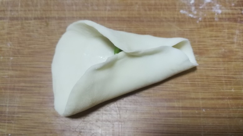 金鱼饺子,放了馅料的半边面片对边捏紧作为金鱼肚子部分,注意留出前段不要捏