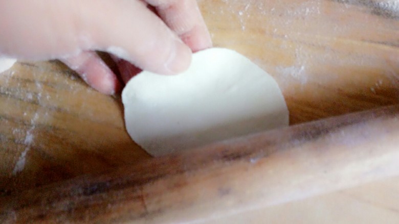 冬至之羊肉馅饺子,取一块,用擀面杖沿着四周擀开,擀成中间后四周薄的面片