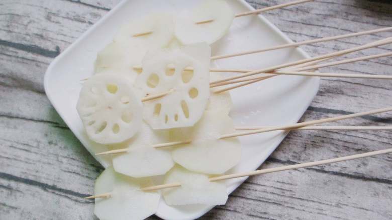 钵钵鸡,莲菜和土豆串在竹签上,这个比较难串,大家要小心应为莲菜特别脆,很容易碎掉