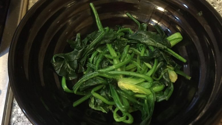 乡味~重庆小吃红油抄手,菠菜放入碗中。