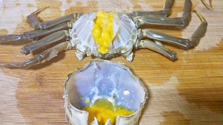 吮指香辣蟹,掰掉大脚,(我一般不用大脚,大脚上太多毛毛了不好处理),把后背壳和蟹身掰开,清理干净内脏,明显看到黄色的膏