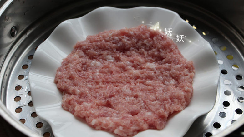 太阳蒸蛋,将肉糜在盘中摊平,四周略高中间略矮,放入蒸锅,水开后中火蒸4分钟。