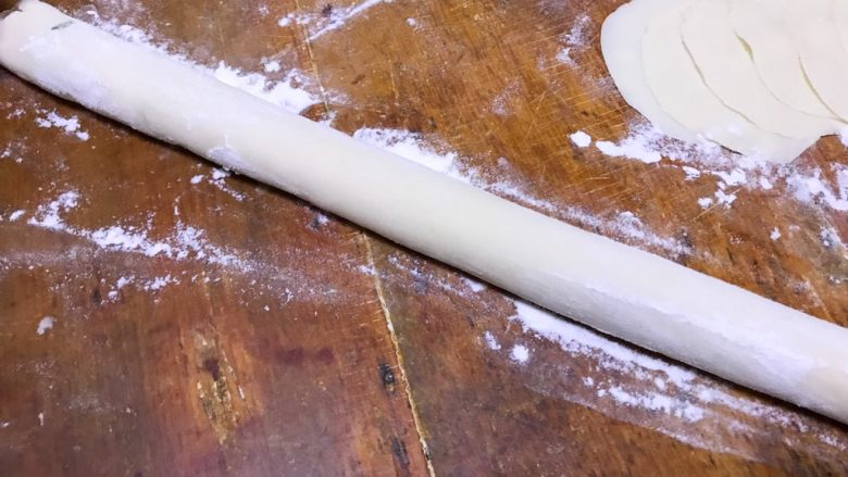 龙利鱼韭菜水饺,取一块小面团,中间挖个洞,用两只手逐渐扩大洞口使其变成环形,然后掐断变成这样的长条形面团(忘拍照了自己脑补)然后撒点干粉搓均匀