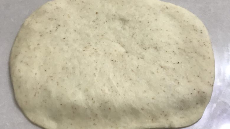 全麦核桃软欧,9翻面再次擀一下你需要的大小,靠近自己的一边用手压薄便于卷后收口捏紧。