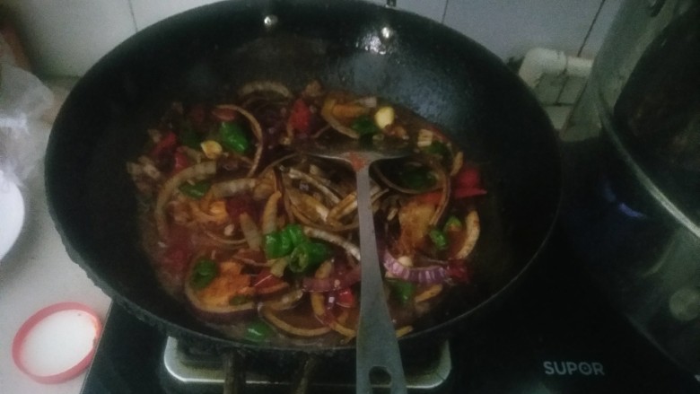 家庭版孜然烤鱼,油烧热,依次加入姜片大蒜花椒青椒,一勺豆瓣酱炒出香味,然后加入细红辣椒,孜然粉两到三勺,加入洋葱,洋葱大半个就够了,然后加入泡椒酸豆角。可以适量加点水加点盐,别加多了。继续翻炒两三分钟就行了。