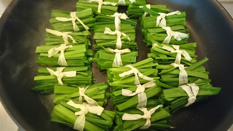 豆皮韭菜,扎好的韭菜豆皮,排進鍋裡慢火煎。