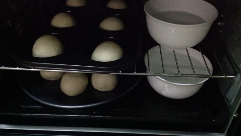 奶黄小餐包,把模具放入烤箱,旁边各放一碗热水,关上烤箱门,进行二次发酵。约30~40分钟。