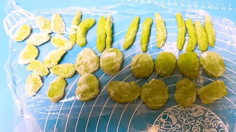 小猪豆沙包,再把菠菜面做成直径1㎝,长3㎝的小条做猪尾巴,再做边长1.5㎝三角形做小猪的耳朵,盖上保鲜膜防止风干备用