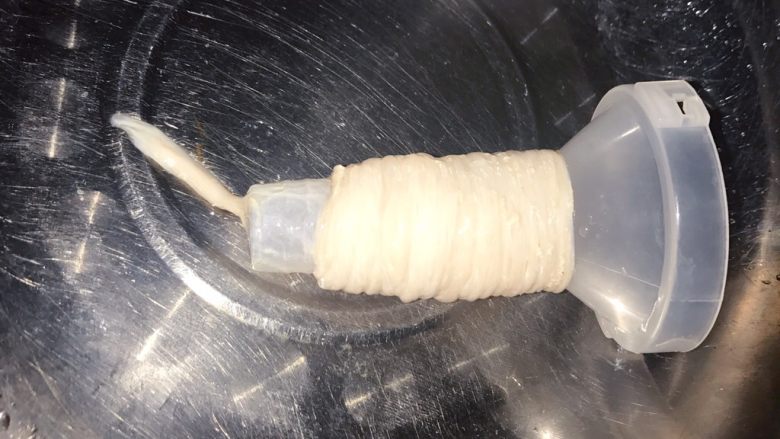 自制热狗烤肠火腿肠,然后把剩下的肠子往灌肠器上套,不要用太大力,肠会破的。套好后,底部打一个疙瘩。