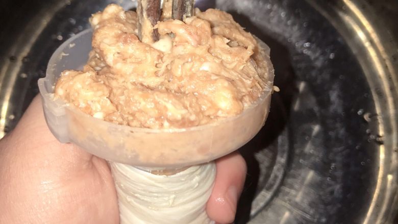 自制热狗烤肠火腿肠,网上有很多方便灌肠的机器,比较好用。我是直接用的绞肉机送的灌肠套筒。把肉放进桶眼里,可以用筷子往下送肉,或者直接用大拇指往下按压肉馅。