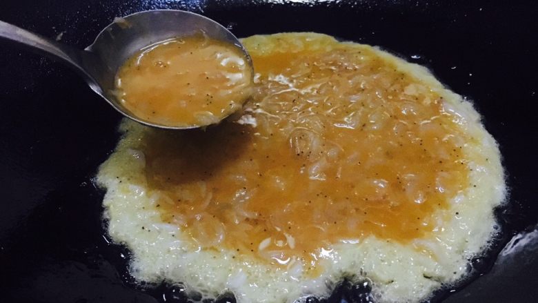 快手早餐 鲜虾皮鸡蛋饼,锅热放入少量的油,改成中小火,盛入总量的一半的鲜虾皮蛋液。