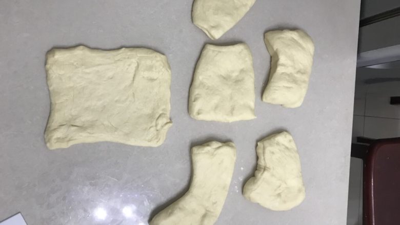 椰浆牛奶吐司,6 倒出来拍打面团排气,拍打整理成长方形。
7 分割面团每个150克6个,余下的做成小面包汉堡什么的。