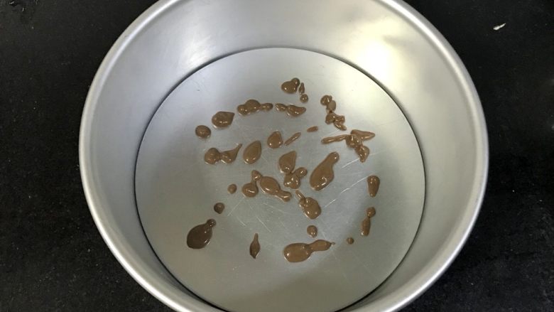 八寸巧克力慕斯巧克力淋面裱花蛋糕,准备八寸模具,在底上零星滴点慕斯液,铺上一片巧克力戚风蛋糕片,冷藏五分钟,固定住就行。