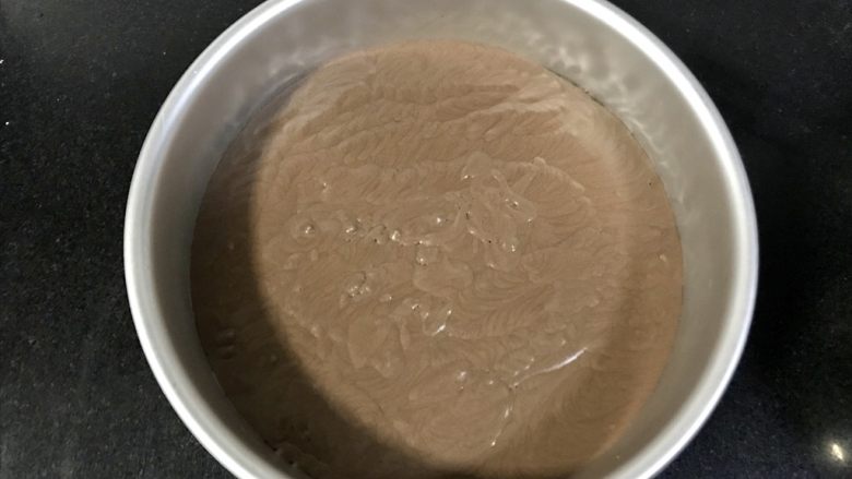八寸巧克力慕斯巧克力淋面裱花蛋糕,从冰箱拿出来后放入一半的慕斯液,再铺一片戚风蛋糕片,冷藏半小时。