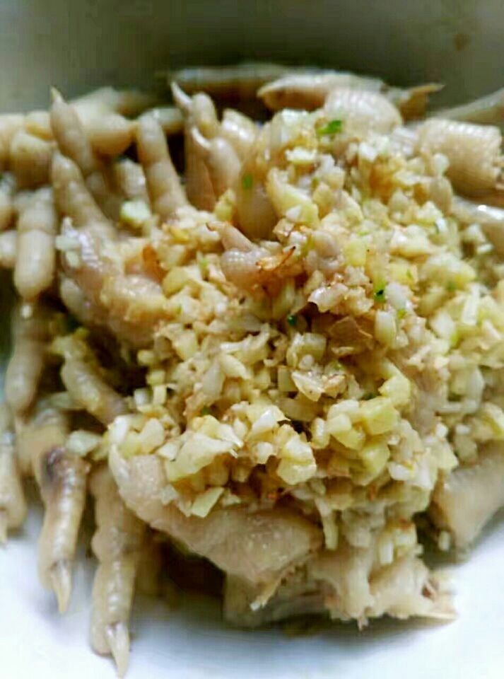 秘密香辣鸡爪,油烧好,小火,把姜蒜炒香,一定要小火,不然会焦,这是第一道撒香,铺在鸡爪上。