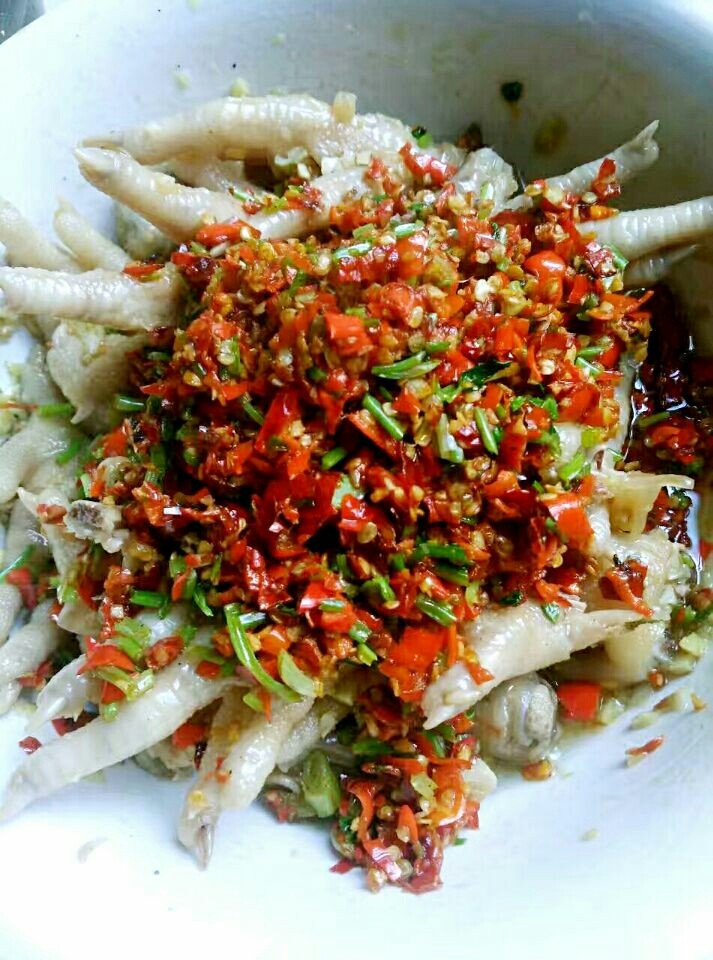 秘密香辣鸡爪,再烧好油,注意用最小火,把辣椒炒香,微微加一点点水,放盐,酱油,香油,味精,鸡精等调料,最后加香菜快速炒盛起来。铺在鸡爪上,这是第二道辣!
