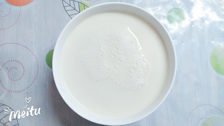 豆腐花捞蜜豆,豆浆煮好后离火两分钟后,迅速倒入融化好的葡萄糖内脂水里,捞去表面的浮沫!这里是豆腐花成败的关键所在,温度要控制在80度左右倒入葡萄糖内脂里才会成功,家里没有温度计,就用离火两分钟的方法也是一样的,一定要记得看时间!