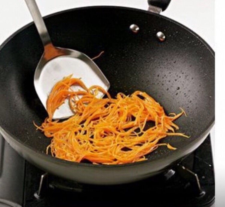 锅包肉,锅中留少量的底油,然后倒入胡萝卜丝,翻炒均匀。
