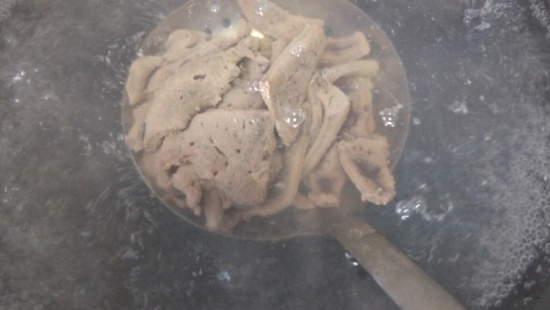 私房酱爆猪肝,锅里水烧开后,猪肝装漏勺放锅里烫至猪肝一变色后捞出备用