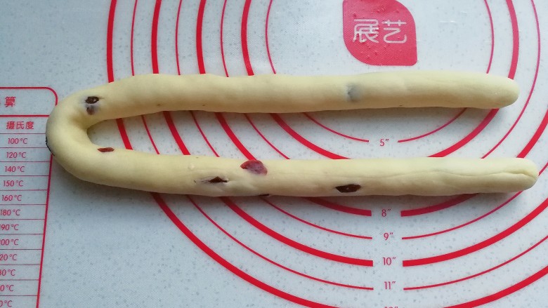 蔓越莓圣诞花环面包,取一份醒好的面团搓成长条;